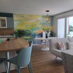 Grande pi&egrave;ce &agrave; vivre avec cuisine &eacute;quip&eacute;e, meuble bar, coin repas et espace salon